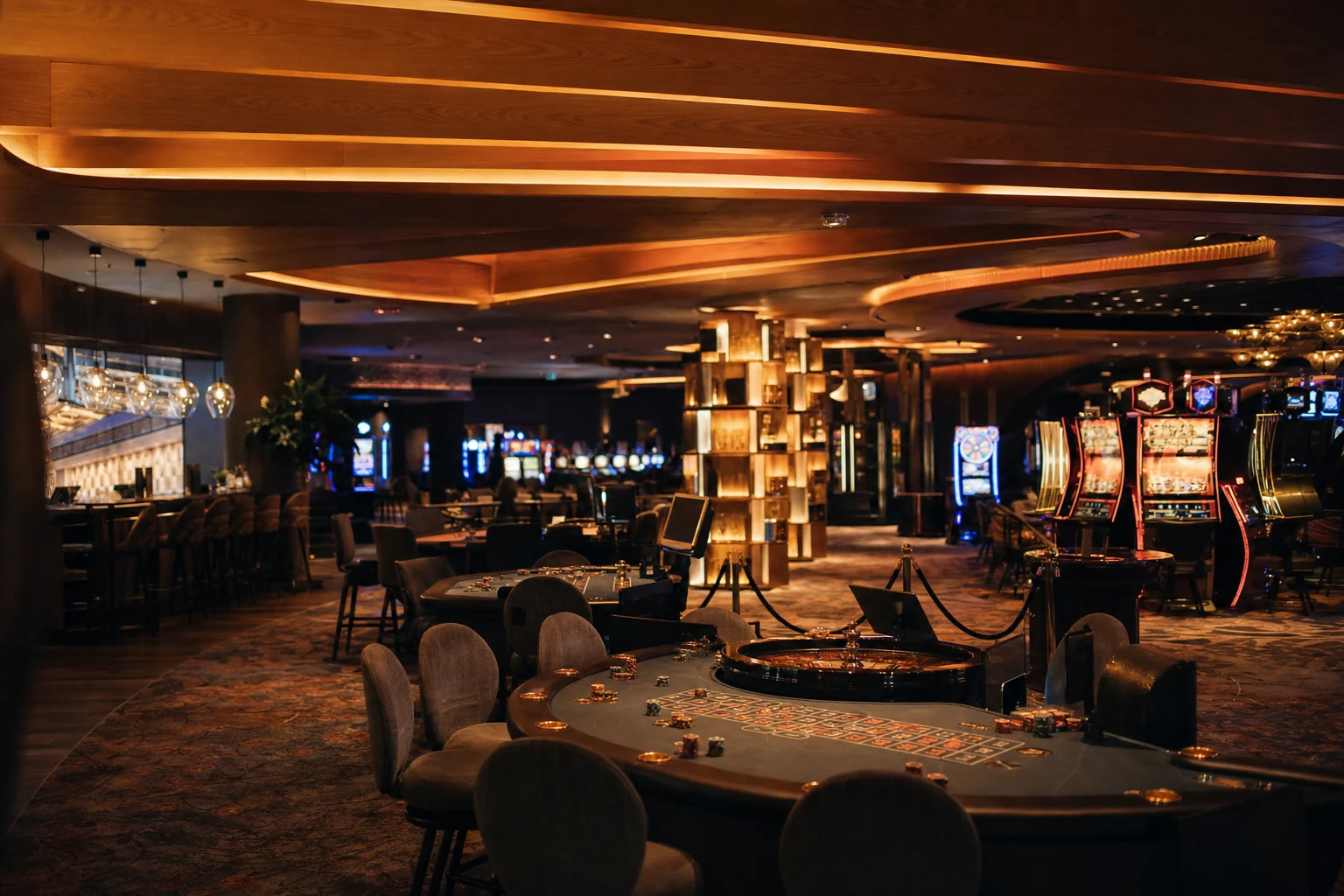 Editorial view of a warm contemporary casino floor with gaming tables and softly illuminated machines